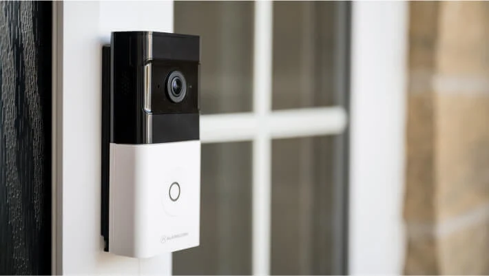 ADT video doorbell fitted beside the glass of a real front door